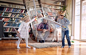 Kids playing with swords and enjoying with parents at home. Family, together, love, playtime