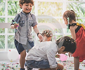 Kids playing and throwing paper and balloon in kid party