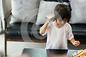 Kids playing with tin can and string phone as communication concept