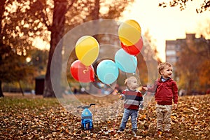 Kids playing together on the autumn park with balloons