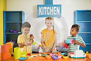 Kids playing with toy kitchen at entertainment center.