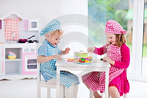 Kids playing with toy kitchen