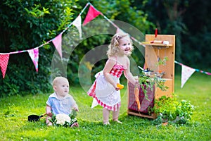 Kids playing with a toy kitchen in a summer garden