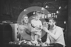 Kids playing with toys. Educational game concept. Parents and their son playing with plastic blocks. Mom helping her son