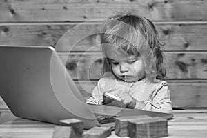 Kids playing with toys. Small boy with computer and phone