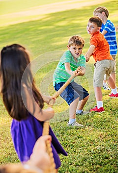 Kids Playing Tug of War On Grass
