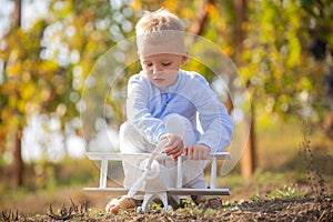 Kids playing with vintage wooden airplane outdoors. Kids having fun with toy airplane in field against nature background