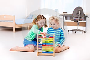 Kids playing with wooden abacus. Educational toy.