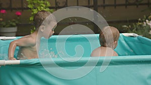 kids in pool having fun happy family concept. two male siblings splash in water