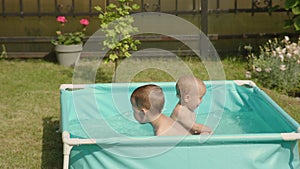 kids in pool having fun happy family concept. two male siblings splash in water