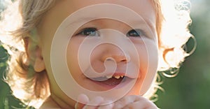 Kids portrait, close up head of cute child. Baby smiling, cute smile on sunny day. Dreamy kids face. Daydreamer child
