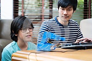 Kids program robotic cranes with laptops to learn about technology, math, engineering. programming and coding at home