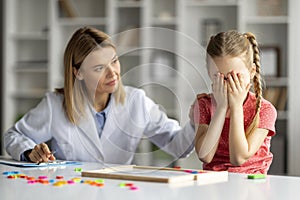 Kids Psychological Problems. Upset little girl crying during therapy session with psychologist