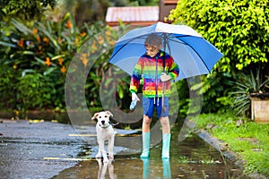 Kids in puddle in autumn rain. Waterproof wear