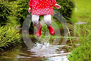 Kids in puddle in autumn rain. Waterproof wear photo