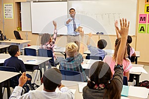 Kids raising hands to answer in an elementary school class