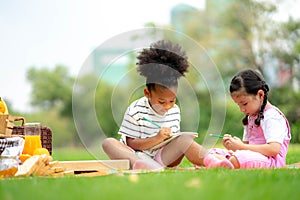 Kids reading a book in summer garden. Children study. Boy and girl play in school yard. Preschool friends playing and learning.