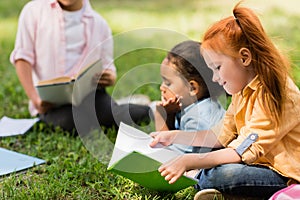 Kids reading books in park
