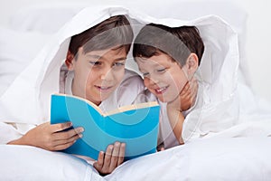 Kids reading under the blanket