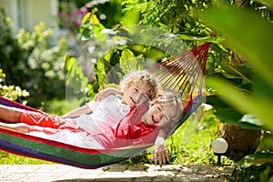 Kids relax in hammock. Summer garden outdoor fun