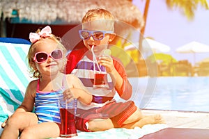 Kids relax on tropical beach resort and drink