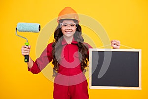 Kids renovation and building concept. Little girl in protective helmet and paint brush for painting walls isolated on