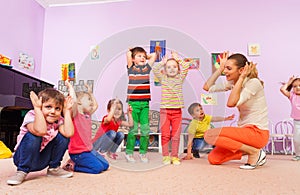 Kids repeat after teacher making ears with hands