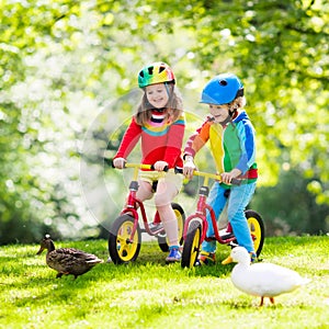 Kids ride balance bike in park