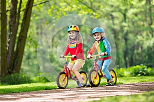 Kids ride balance bike in park