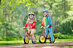 Kids ride balance bike in park