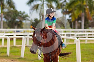 Kids ride horse. Child on pony. Horseback riding