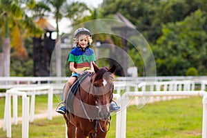 Kids ride horse. Child on pony. Horseback riding