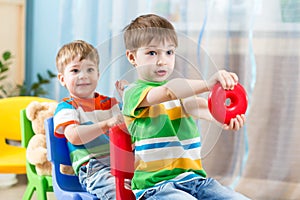 Kids riding on carriages made from chairs