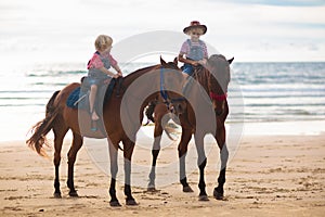 Kids riding horse on beach. Children ride horses