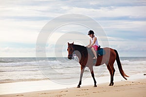 Kids riding horse on beach. Children ride horses