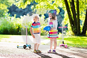 Kids riding scooter in summer park.