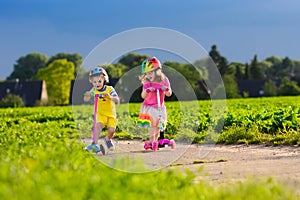 Kids riding scooter on sunny summer day