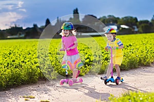 Kids riding scooter on sunny summer day photo