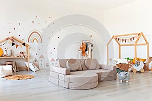 Kids room interior in contemporary, Scandinavian style. Wooden bed, sofa and toys. Cozy room for child.