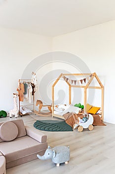 Kids room interior in contemporary, Scandinavian style. Wooden bed, sofa and toys. Cozy room for child.