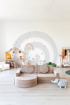 Kids room interior in contemporary, Scandinavian style. Wooden bed, sofa and toys. Cozy room for child.