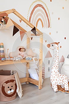 Kids room interior in contemporary, Scandinavian style. Wooden bed, sofa and toys. Cozy room for child.