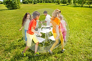 Kids run around playing musical chairs game