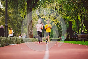 Kids run. Healthy sport. Child sport, heterosexual twins running on track, fitness. Joint training. Running training outdoor