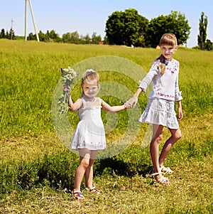 Kids running across green grass outdoor.