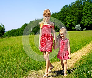 Kids running across green grass outdoor.