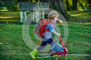 Kids running on green field countryside at green background Little child boy with hikers backpack travelling on Camp