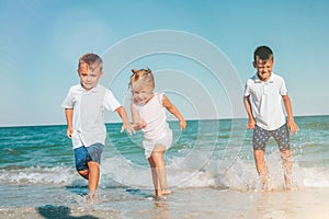 A kids running on the seashore with waves