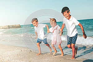 A kids running on the seashore with waves