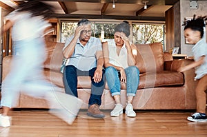 Kids running, stress and grandparents on sofa tired and chaos in living room with frustrated grandpa and grandma